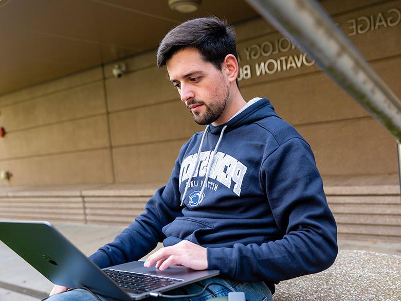 全球网赌十大网站的男学生正在用笔记本电脑工作